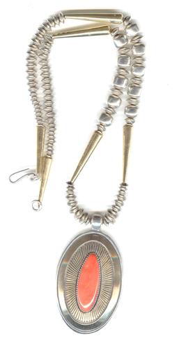 Mediterranean coral on oval silver and 14 kt gold pendant, finely chiseled lines in sunburst design, on silver and gold beads.